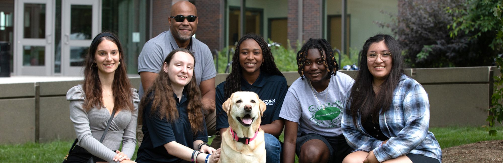 UConn First Summer students posing for photo with canine and UCFS director