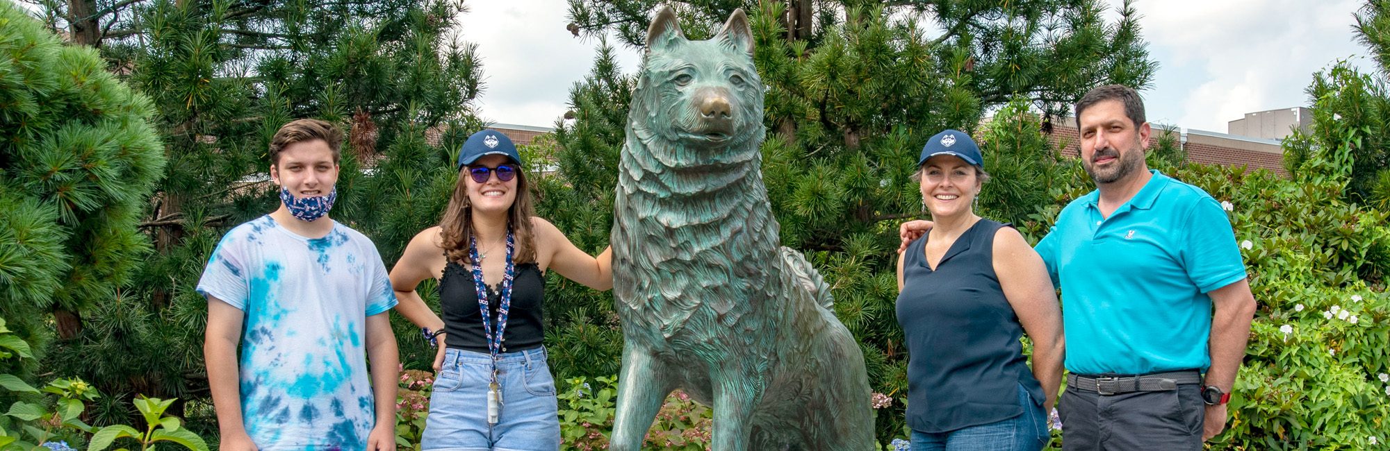 Family posing around the UConn Husky statue